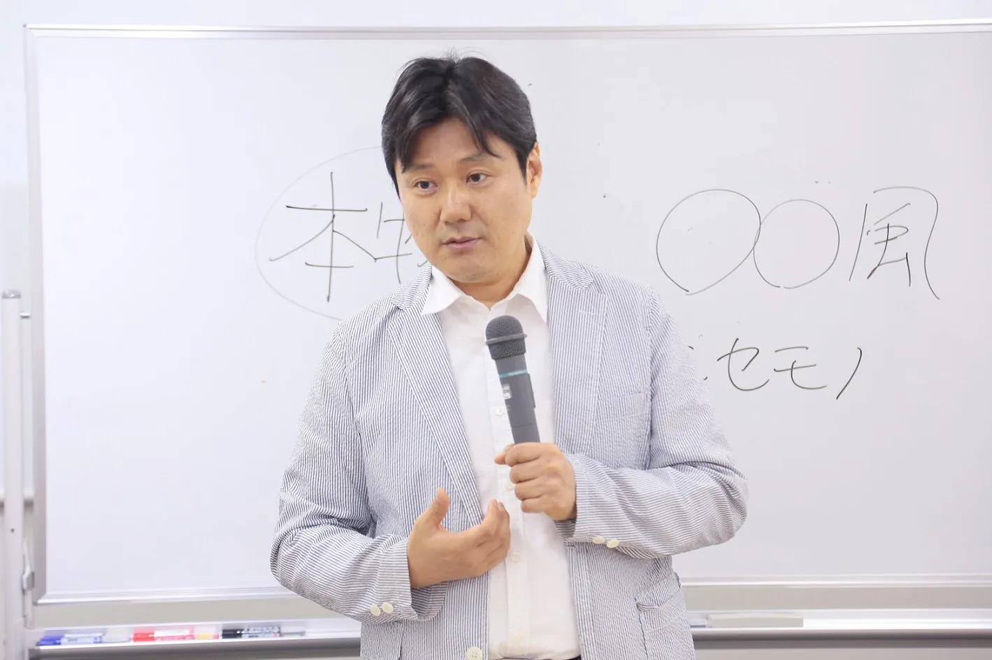 ホワイトボードを使って説明する講師